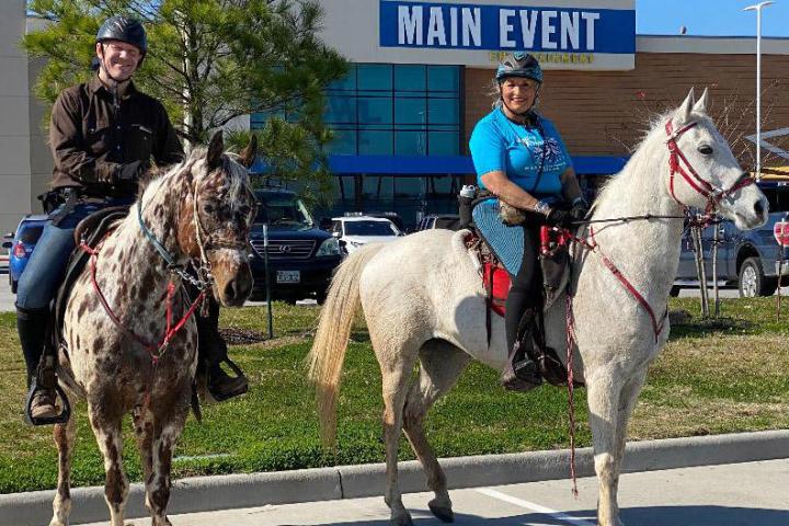 a group of people riding horses on a city street