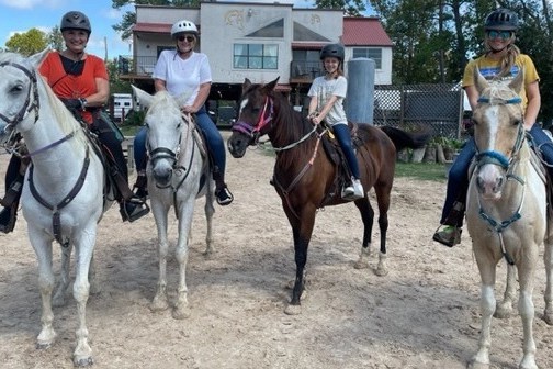 a group of people standing next to a horse