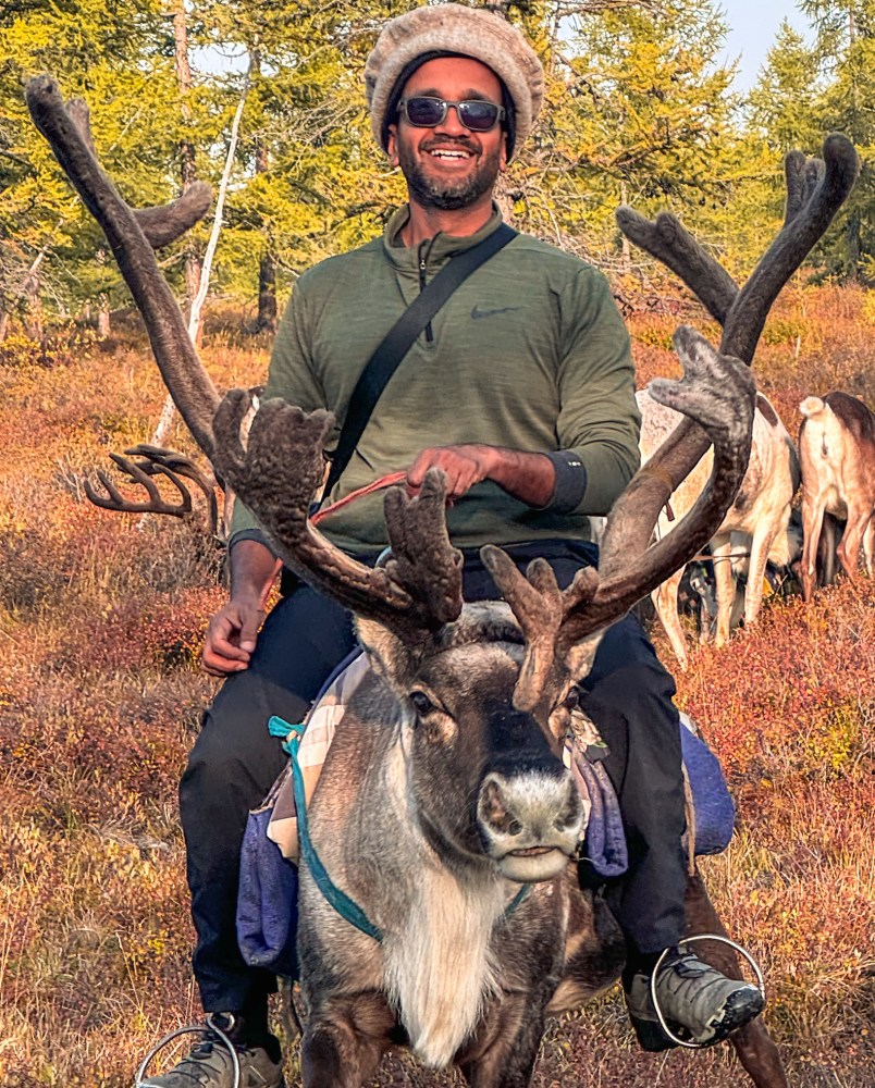 a man holding a deer on grass